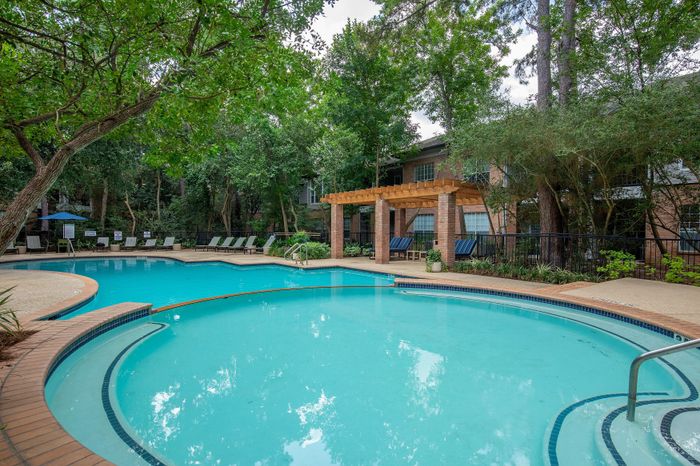 Inviting outdoor pool area surrounded by lush greenery and modern seating, perfect for relaxation and entertaining.