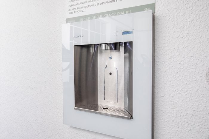 Modern stainless steel water dispenser integrated into a sleek wall design, ensuring easy access in a stylish environment.