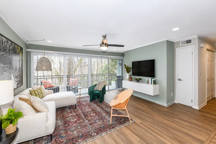 Modern apartment living room with floor-to-ceiling windows at Avana Cumberland in Atlanta, GA.