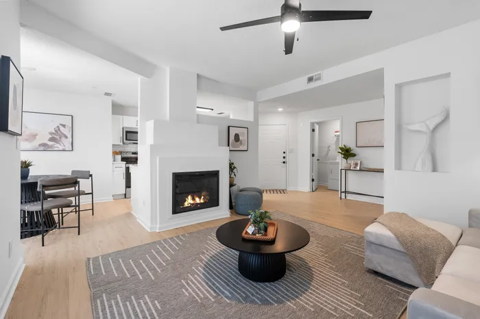 Modern living room with a cozy fireplace, stylish furniture, and an open dining area.