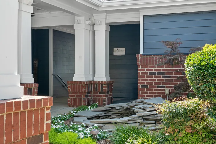 Charming exterior view of a stylish entrance with elegant brickwork and lush greenery offering inviting curb appeal.