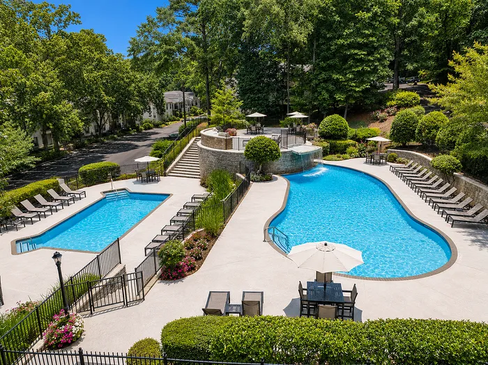 Luxurious twin pools surrounded by lush greenery and elegant lounge chairs, offering a serene retreat for relaxation and leisure.