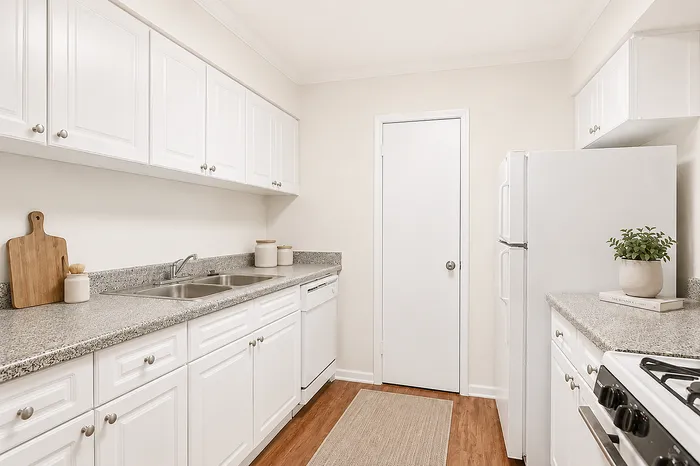 Bright and modern kitchen with white cabinetry, granite countertops, and stainless steel appliances, perfect for culinary enthusiasts.