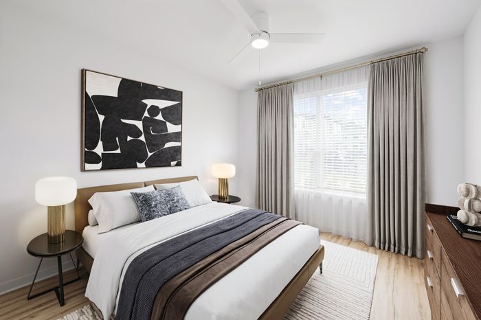 Elegant bedroom featuring a plush bed with stylish cushions, modern art on the wall, ambient lighting on sleek bedside tables, and a large window with flowing curtains.