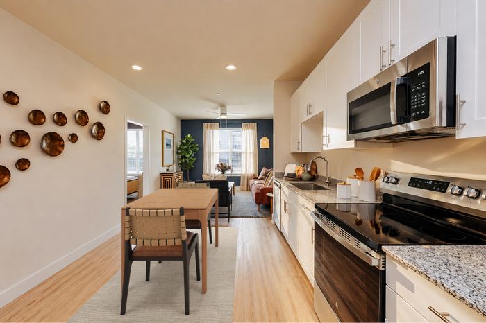 Modern open-concept kitchen and living area with stylish decor, natural light, and elegant dining space.