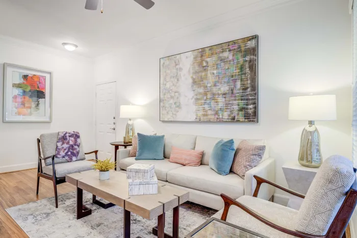 Chic living room with a cozy sofa, vibrant artwork, and elegant lighting creating a warm, inviting atmosphere.