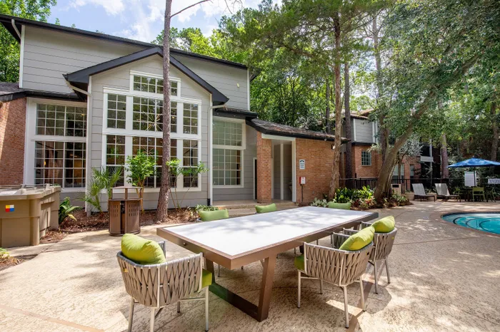 Inviting outdoor space featuring a modern seating area beside a refreshing pool in a beautifully landscaped apartment complex.