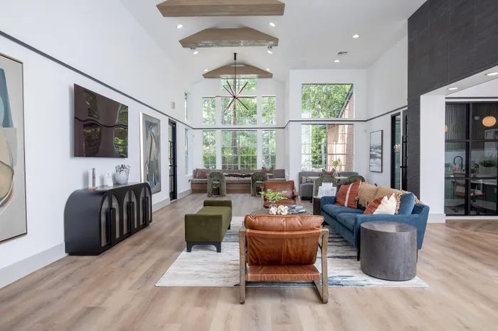Luxurious open-concept living area with stylish decor, featuring a cozy seating arrangement, large windows for natural light, and elegant wood flooring for a modern touch.