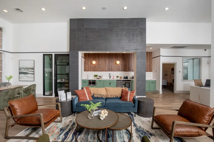 Contemporary lobby area with stylish seating, vibrant decor, and a sleek kitchenette with green cabinetry.