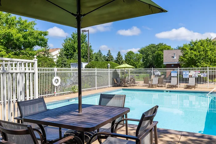 Inviting outdoor pool area with stylish seating and lush greenery, perfect for relaxation and leisure.