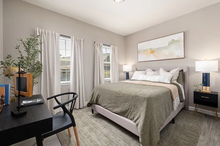 Elegant bedroom with soft lighting, plush bed, and chic workspace, creating a serene retreat.