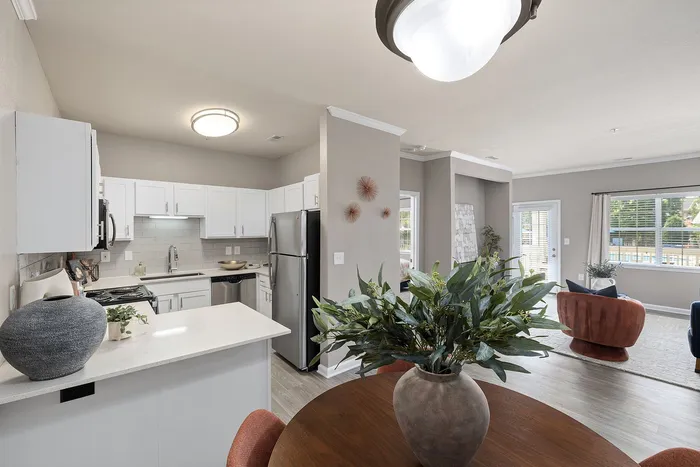 Bright and airy open-concept kitchen and living area with modern appliances and stylish decor, featuring large windows letting in natural light.