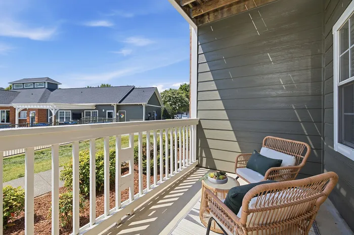 Inviting porch with stylish wicker chairs and lush garden views, perfect for relaxing and enjoying sunny days.