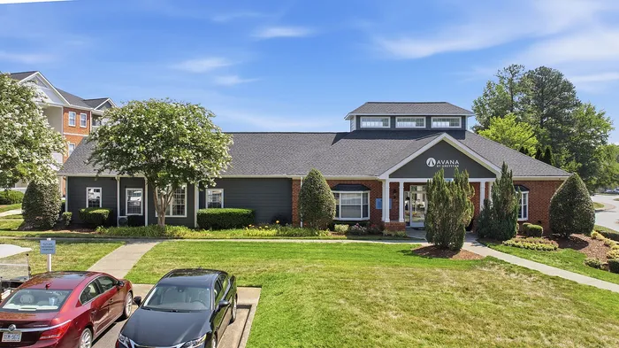 Inviting apartment complex with manicured landscaping, vibrant greenery, and a modern entrance, offering a welcoming community atmosphere.
