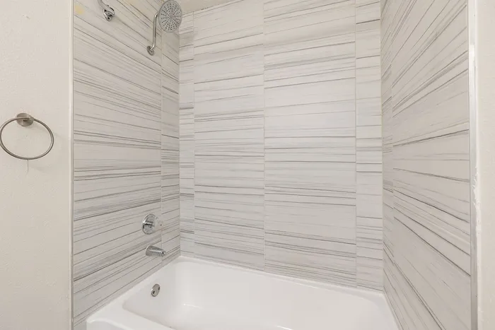 Luxurious bathroom with elegant striped tiling and modern shower fixtures, creating a serene spa-like ambiance.