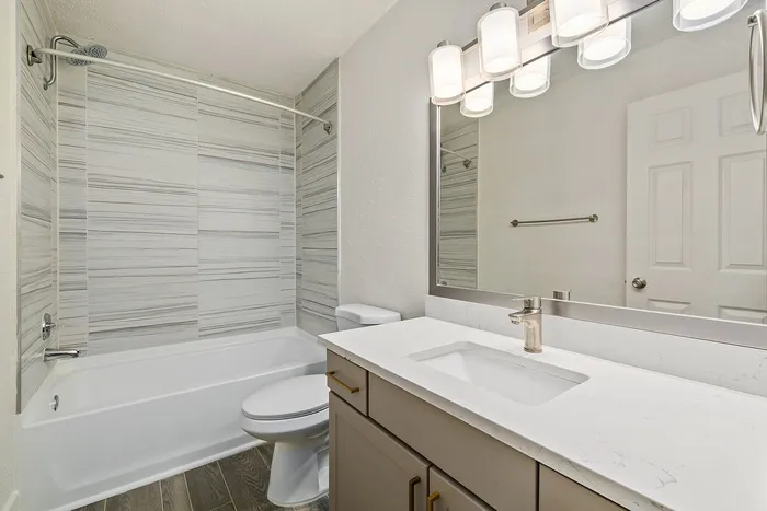 Elegant bathroom with modern fixtures, featuring a stylish bathtub, sleek vanity, and contemporary lighting.