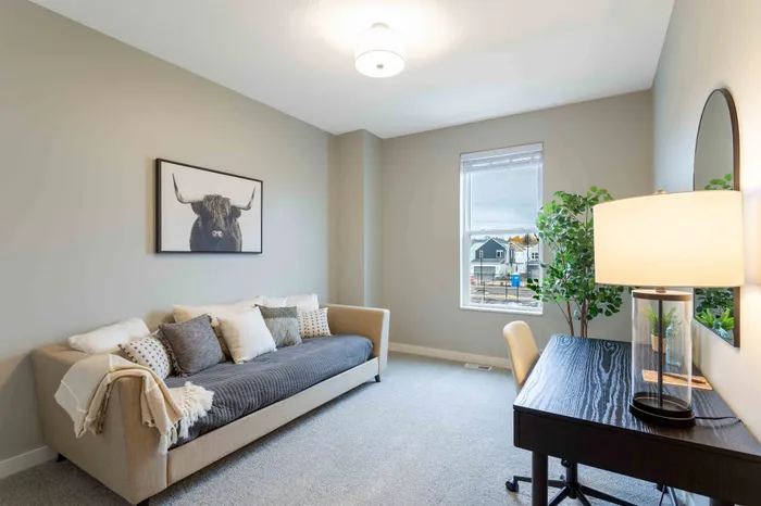 Inviting room with a cozy sofa and stylish decor, featuring a large window with a scenic view. Perfect for relaxing or working from home.