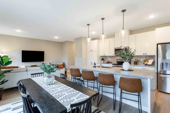 Contemporary open-plan living space featuring a stylish kitchen with modern appliances and a cozy dining area, perfect for entertaining.