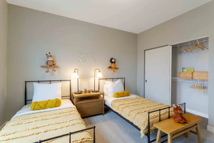 Cozy and inviting children's bedroom with twin beds, playful decor, and ample closet space.