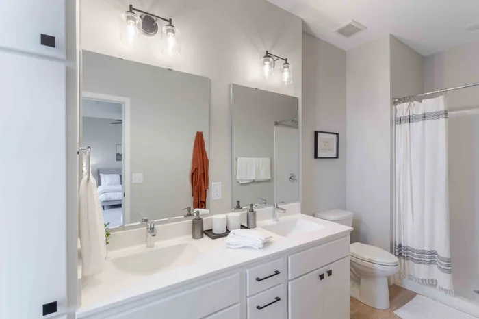 Elegant bathroom featuring dual sinks with modern fixtures, stylish lighting, and a cozy ambiance.