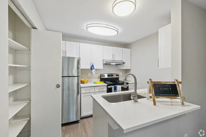Modern kitchen with sleek stainless steel appliances, elegant white cabinetry, and a welcoming atmosphere.