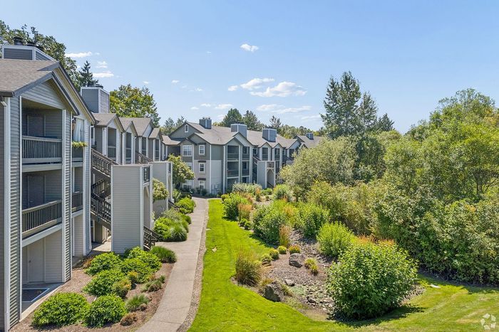 Charming residential complex with modern architecture, surrounded by lush greenery and vibrant gardens, offering a peaceful and inviting atmosphere.