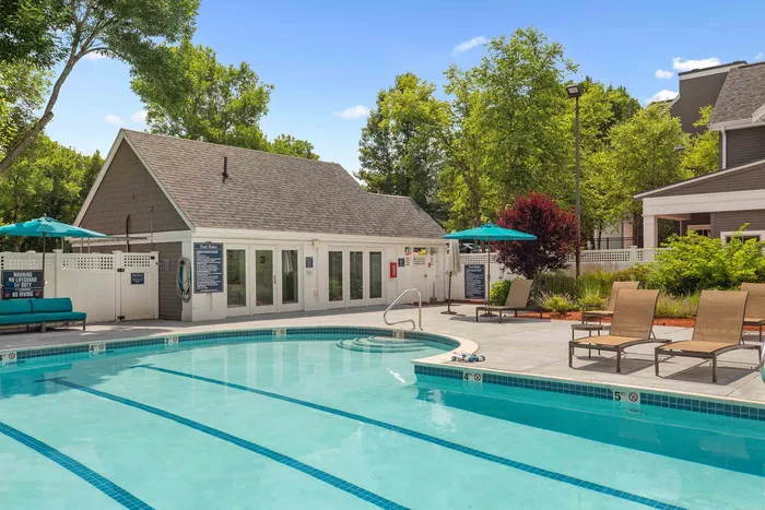 Inviting outdoor pool area surrounded by lush greenery and comfortable lounge chairs, perfect for relaxation and leisure.