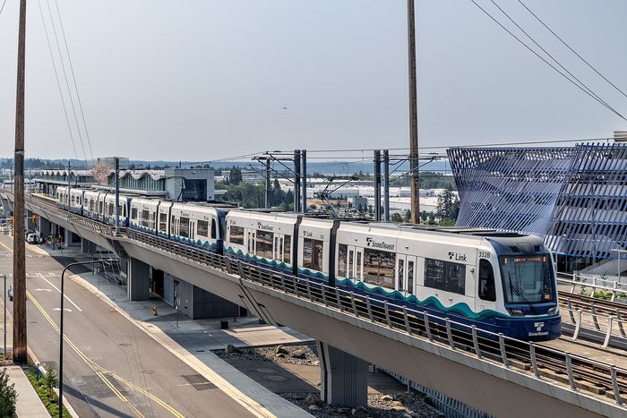 Modern elevated train traveling on a sleek overpass, with contemporary architecture in the background, showcasing urban transport efficiency.