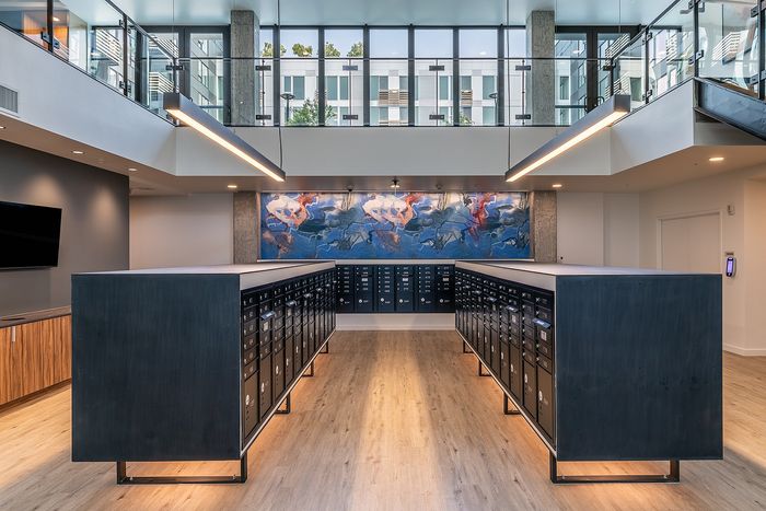 Modern lobby with sleek mailboxes, elegant lighting, and vibrant artwork creating a welcoming atmosphere.