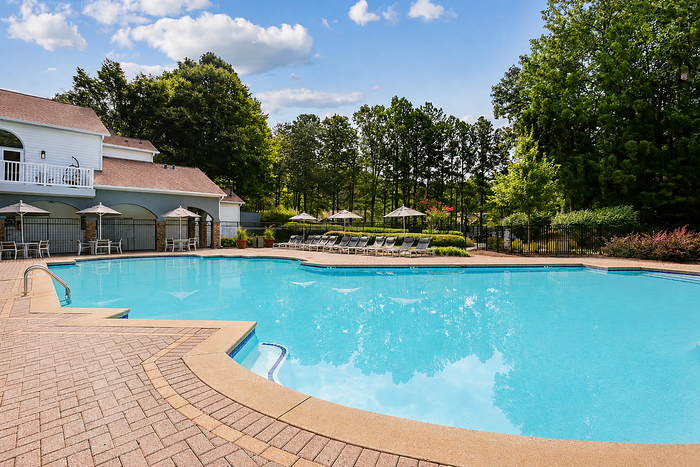 Resort-inspired pool deck with lounge chairs and umbrellas at Avana TownPark apartments in Kennesaw, GA