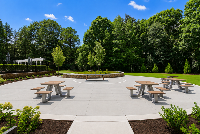 Outdoor dining area with picnic tables and grilling stations at Avana TownPark in Kennesaw, GA