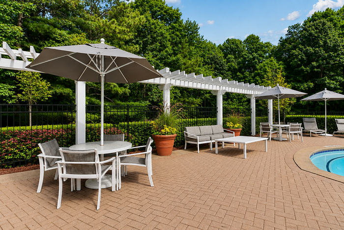 Outdoor sitting tables beneath a pergola at Avana TownPark apartments in Kennesaw, GA