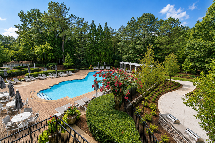 Resort-inspired swimming pool with lounge seating at Avana TownPark apartments in Kennesaw, GA