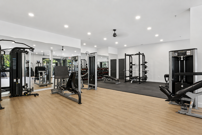 Strength training area with workout equipment and mirrors at Avana TownPark apartments in Kennesaw, GA