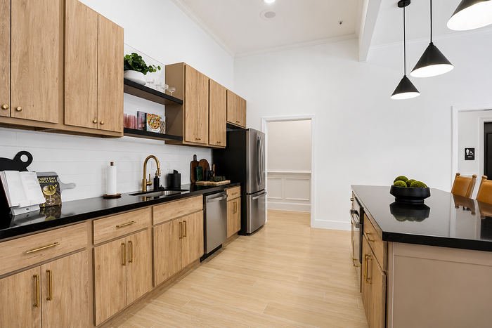 Clubhouse community kitchen with wood cabinetry, stainless steel appliances and island at Avana TownPark in Kennesaw, GA