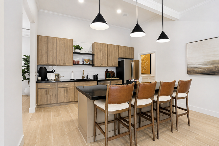 Community kitchen with island bar seating and stainless steel appliances at Avana TownPark in Kennesaw, GA