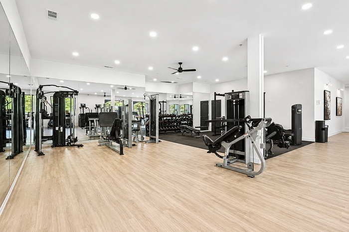 Contemporary fitness center with state-of-the-art gym equipment and sleek wooden flooring.