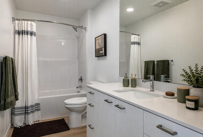 Elegant bathroom featuring a modern vanity, sleek faucet, and a cozy bathtub with stylish decor accents.