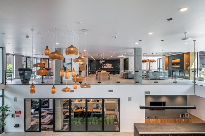 Modern, open-concept loft apartment with elegant hanging lights, large windows, and contemporary furnishings.