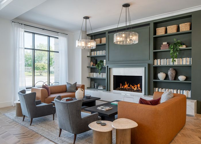 Luxurious living room with elegant sofas, modern fireplace, and chic decor, complete with a large window offering a scenic view.