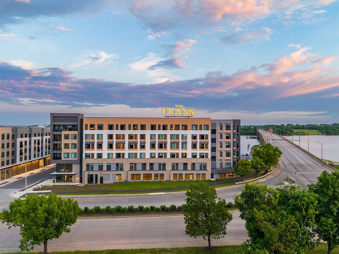 Stunning riverside apartment complex at sunset with modern architecture and vibrant ambiance.