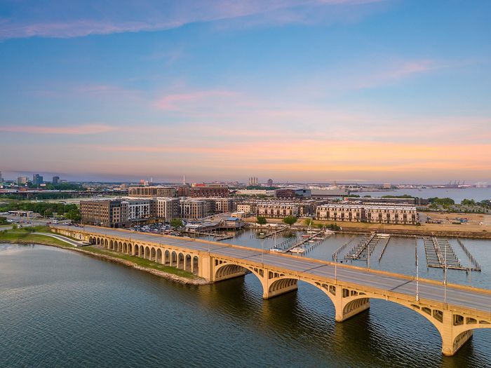 Breathtaking aerial view of modern waterfront apartments with elegant architecture and picturesque sunset over the bay.