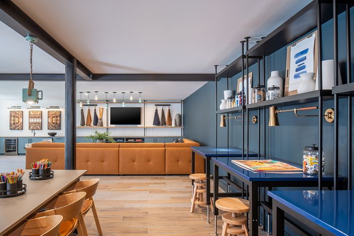 Contemporary living area with stylish open-concept design, featuring a plush caramel sofa, sleek shelving, and vibrant accent walls.