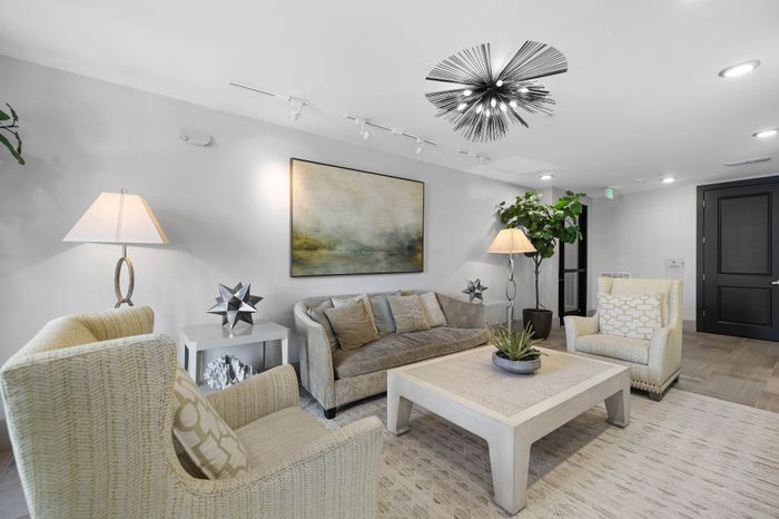 Elegant living room with modern decor, lush plants, and sophisticated lighting, offering a serene and stylish ambiance.