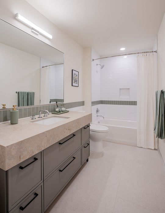 Elegant bathroom with modern fixtures, a spacious vanity, and chic tile design.