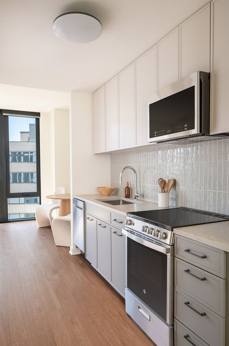 Modern kitchen with sleek cabinetry, stainless steel appliances, and inviting natural light from large windows.