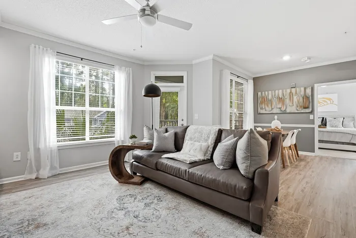 Inviting living room with an elegant leather sofa, chic decor, and abundant natural light highlighting the spacious open-concept design.