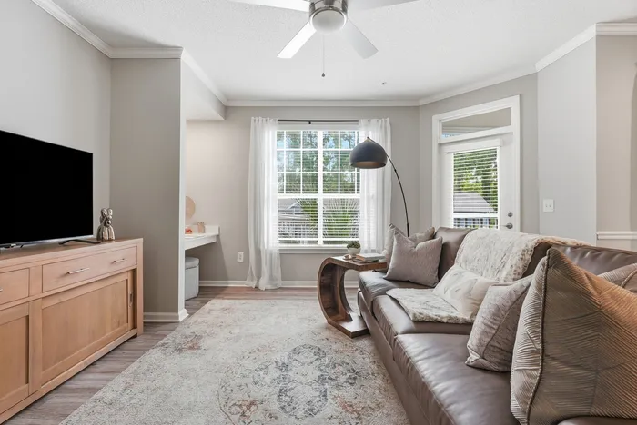 Inviting living room with cozy leather sofa, stylish decor, and abundant natural light from large windows.