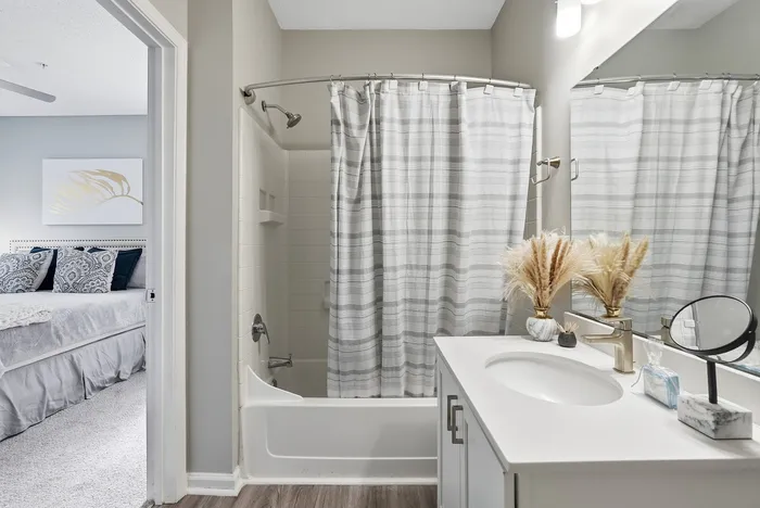 Elegant bathroom with modern fixtures, a cozy bedroom view, and chic decor, offering a serene living experience.