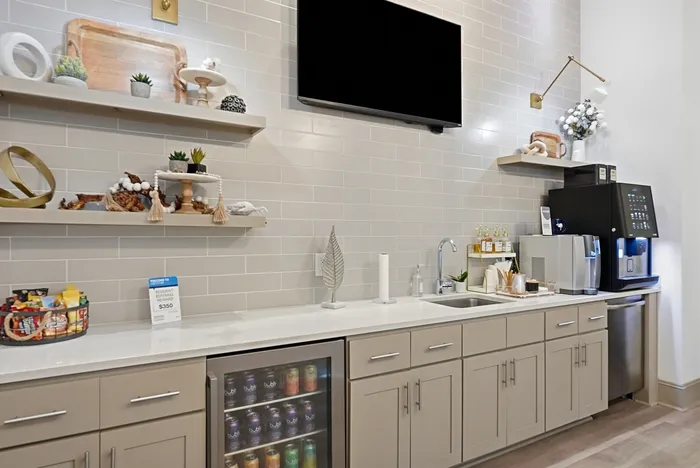 Modern kitchenette area with stylish shelving, decorative accents, and a beverage cooler, perfect for entertaining and relaxation.